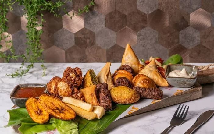 Afrikaanse borrelplank met samosa's, kipvleugels, cassave en gebakken banaan
