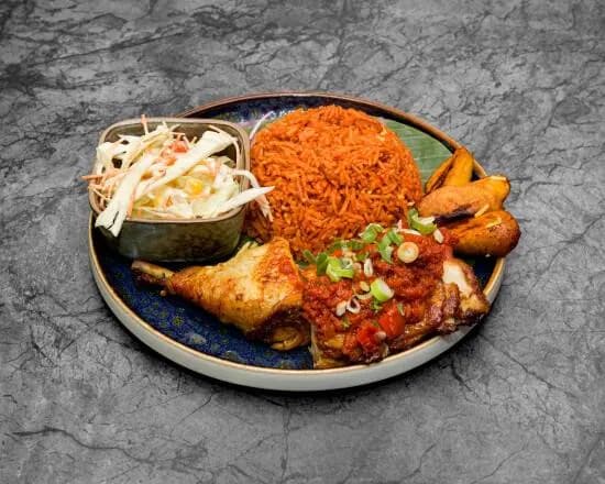 Jollof rijst met BBQ kip, gebakken banaan en koolsalade